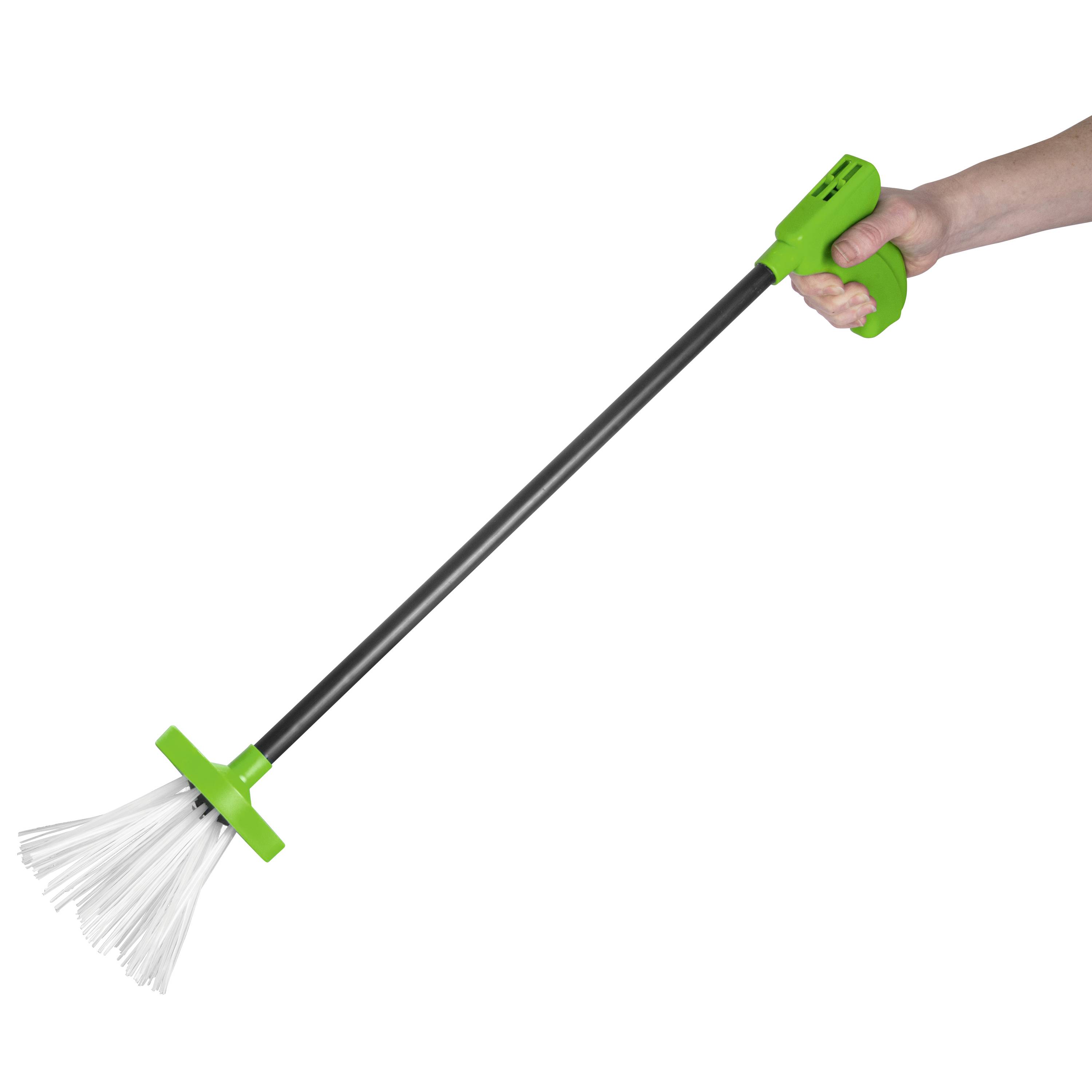 Een hand houdt een langstelige borstel vast met een groene handgreep en witte borstelharen.