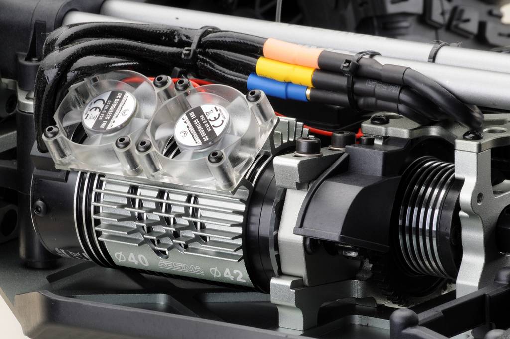 Close-up van een mechanisch onderdeel met drie ventilatoren en gekleurde kabels. Het lijkt deel uit te maken van een groter machinemodel.