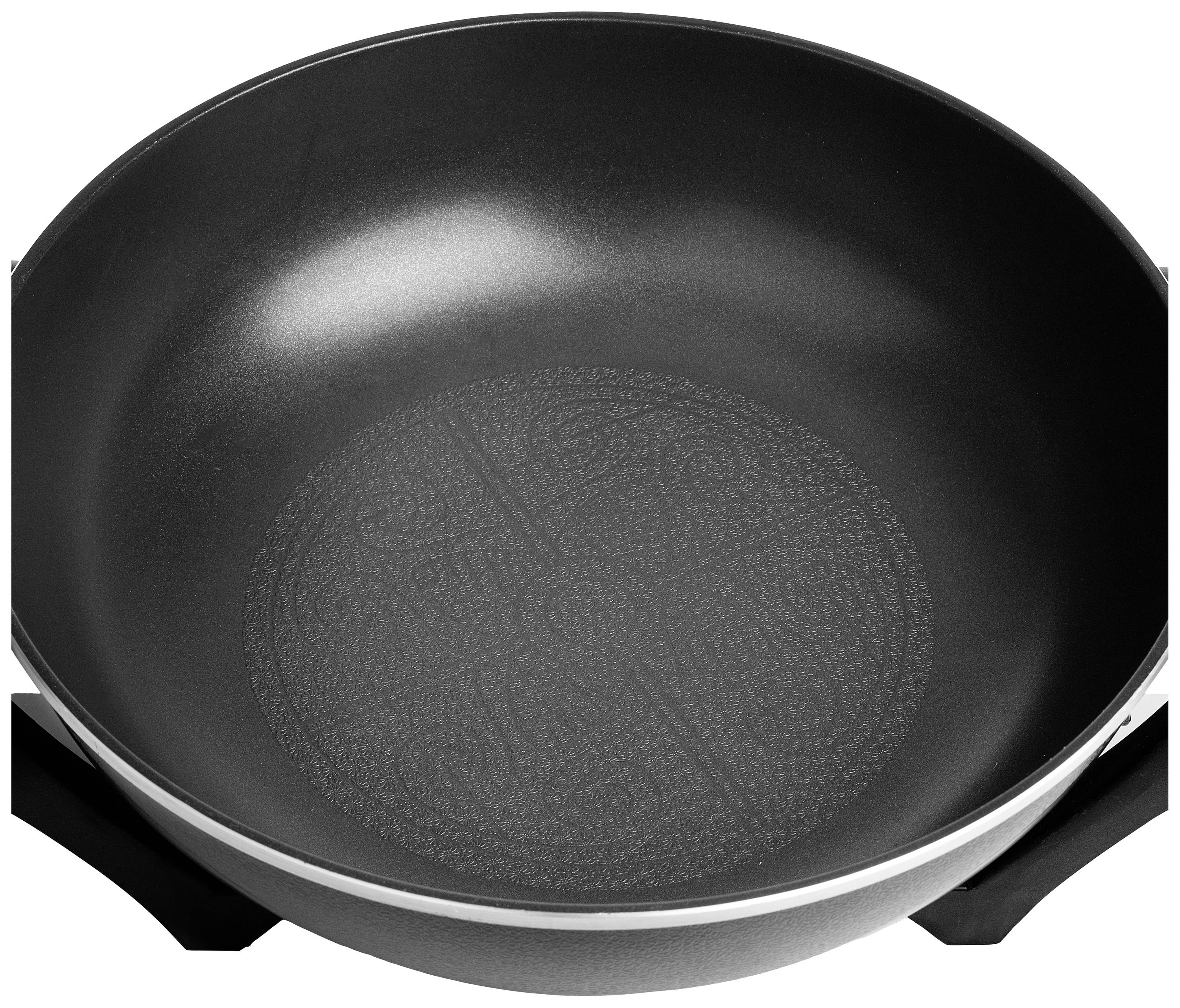 Zwarte anti-aanbakpan met zilveren rand, cirkelvormig patroon op de bodem, geschikt voor koken bij gemiddelde tot hoge temperaturen.