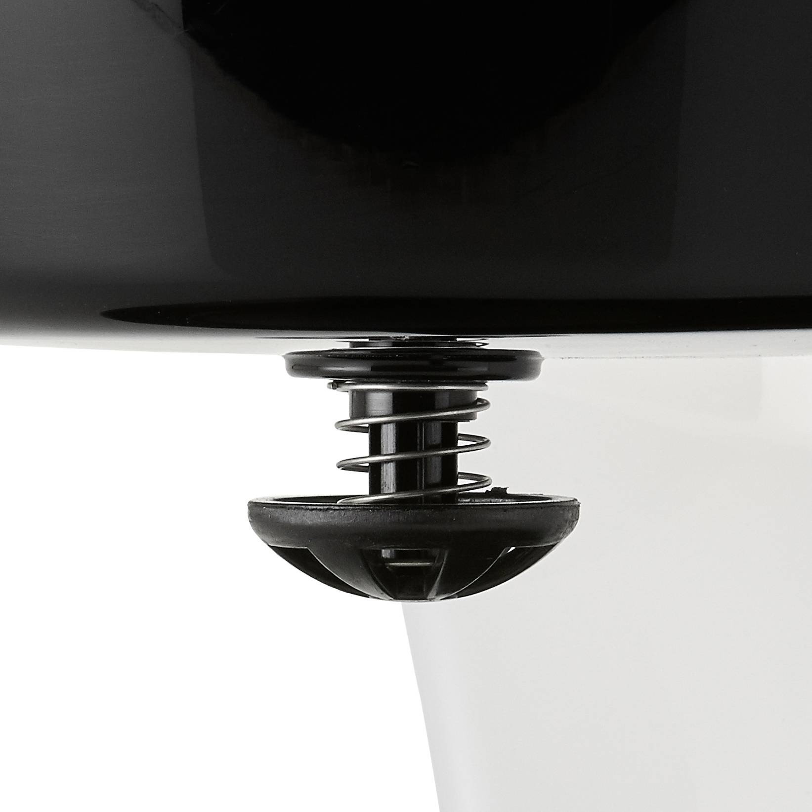 Een zwarte pop-up afvoerplug in een wit wastafel, gedeeltelijk geopend, toont de functionaliteit voor waterafvoer of -retentie.