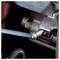 Een close-up van een motoronderdeel met een handgereedschap dat een bout aanstelt, wat illustreert dat onderhoud of reparatie in uitvoering is.