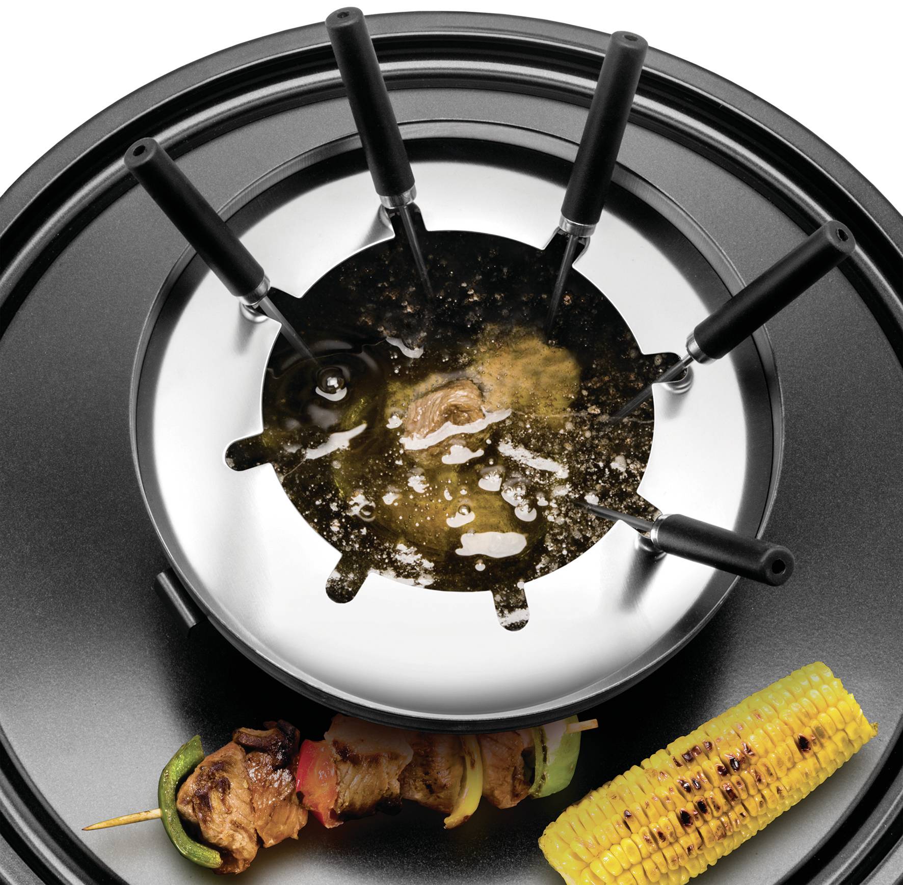 Fondueset met vlees en groenten aan spiesen. Maiskolven ernaast. Tafereel dat gezelligheid en gezamenlijk eten uitstraalt.