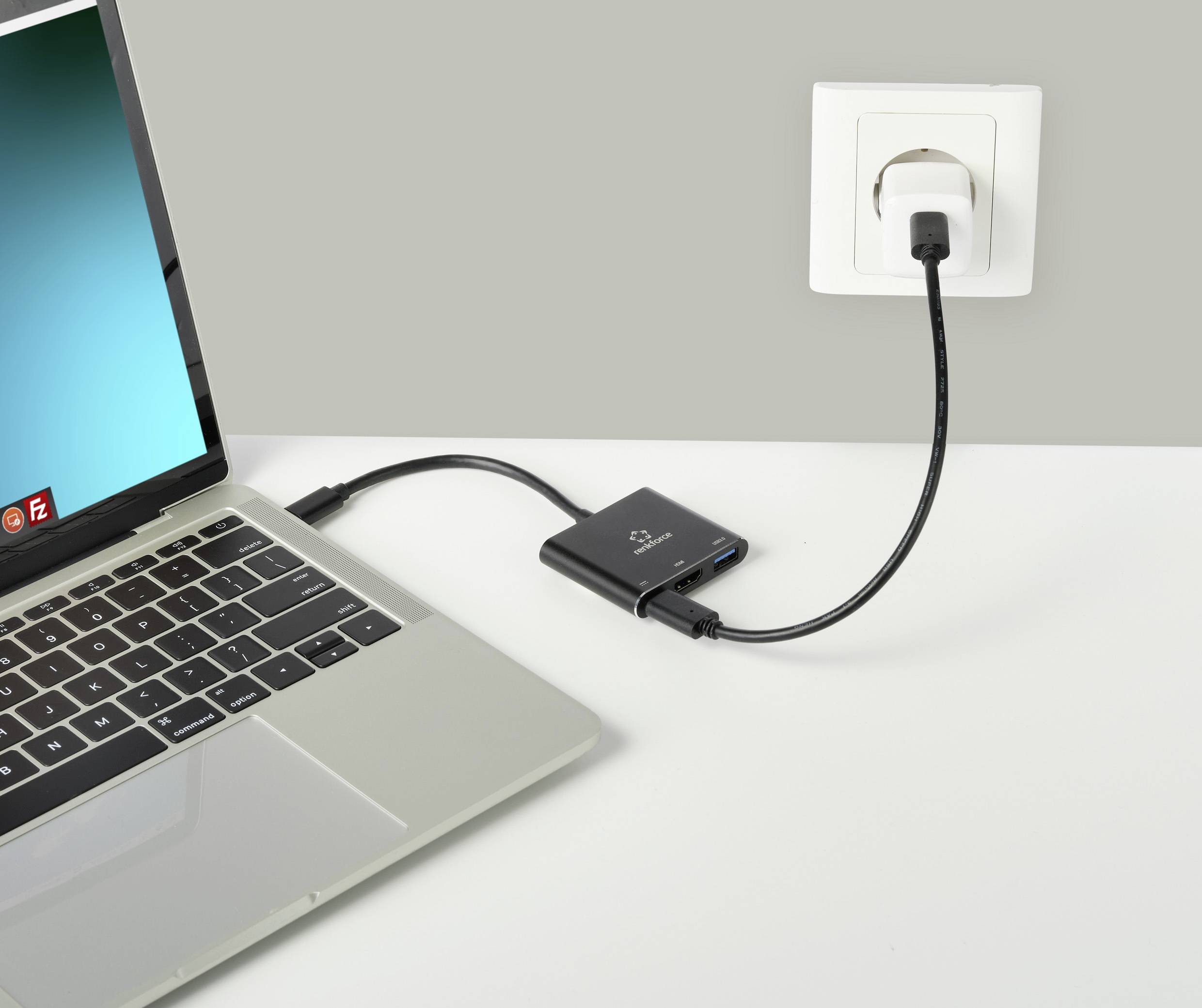 Een laptop is aangesloten op een voedingsadapter die in een stopcontact is gestoken. Een adapterkabel verbindt de laptop met de voedingsadapter.