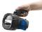 Een hand houdt een zwarte en blauwe zaklamp met grote reflector vast.