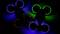 Twee drones met kleurrijke LED-verlichting die rood, blauw en groen schijnen, vliegen in het donker. De ringen rond de propellers zijn verlicht.