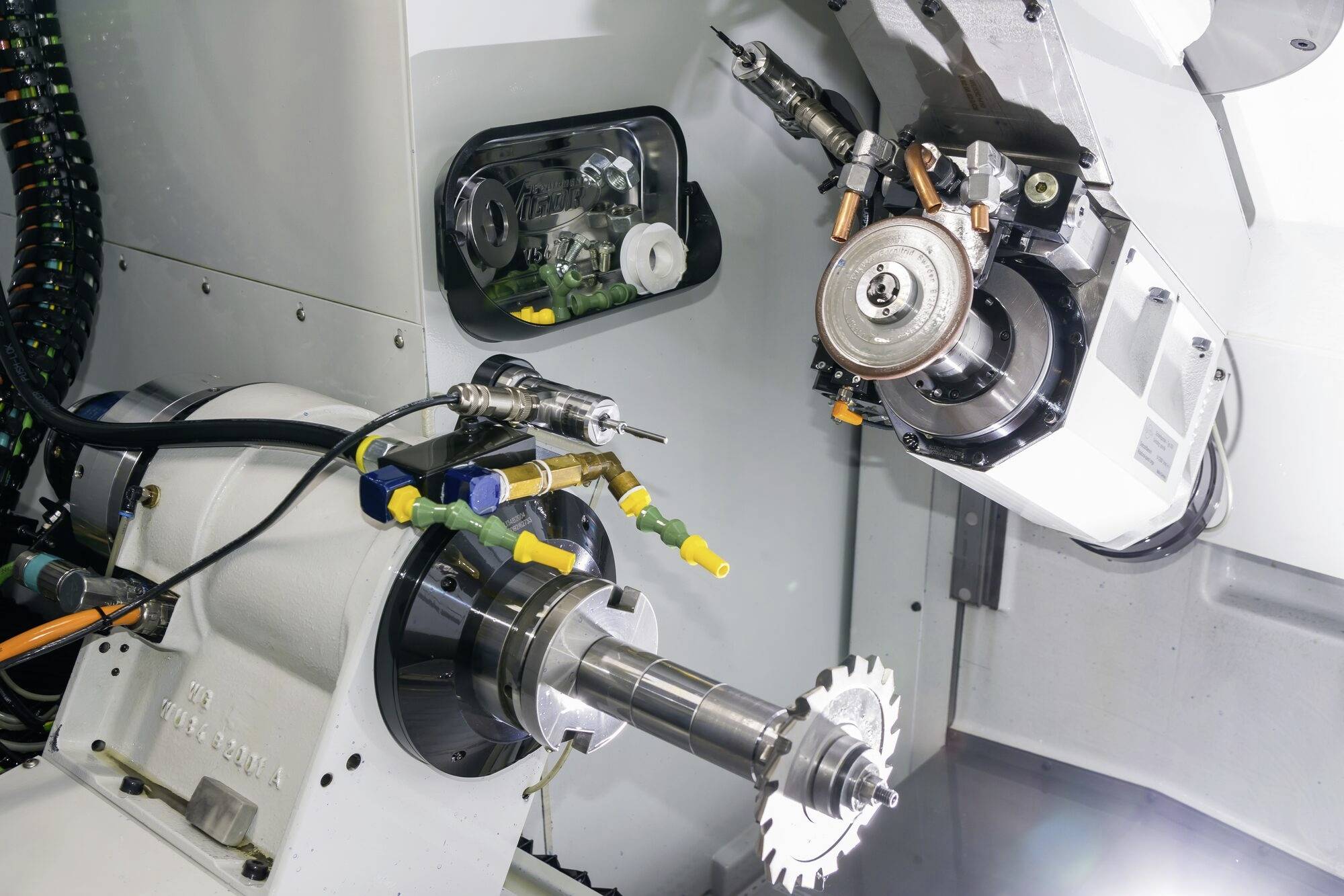 Industriële robotarm werkt met metaalfreesmachine in een werkplaats. Componenten en gereedschappen bevestigd aan metaal.