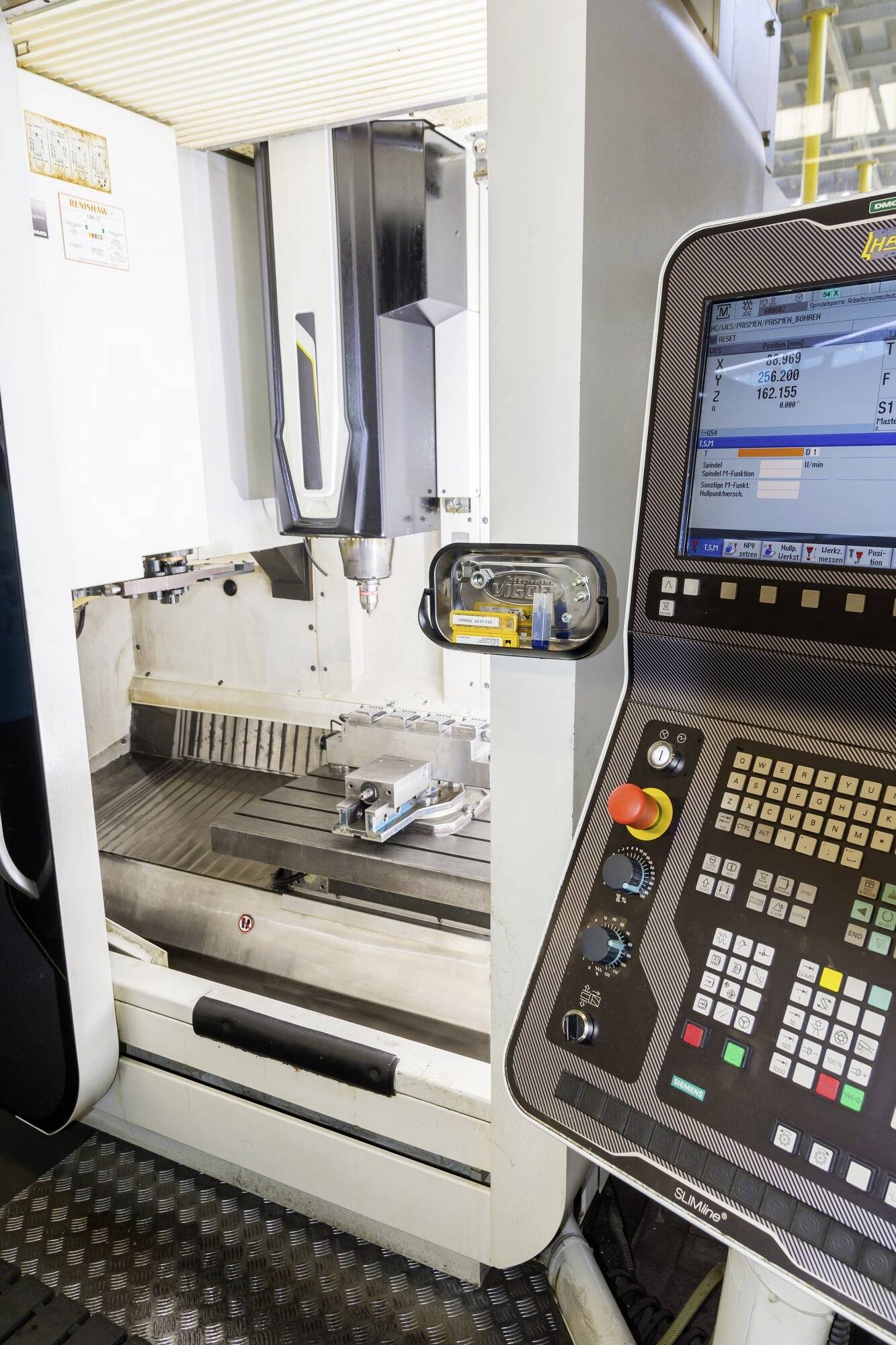 Industriële machine in een werkplaats met een bedieningspaneel en een meterkbewerkingsgereedschap.