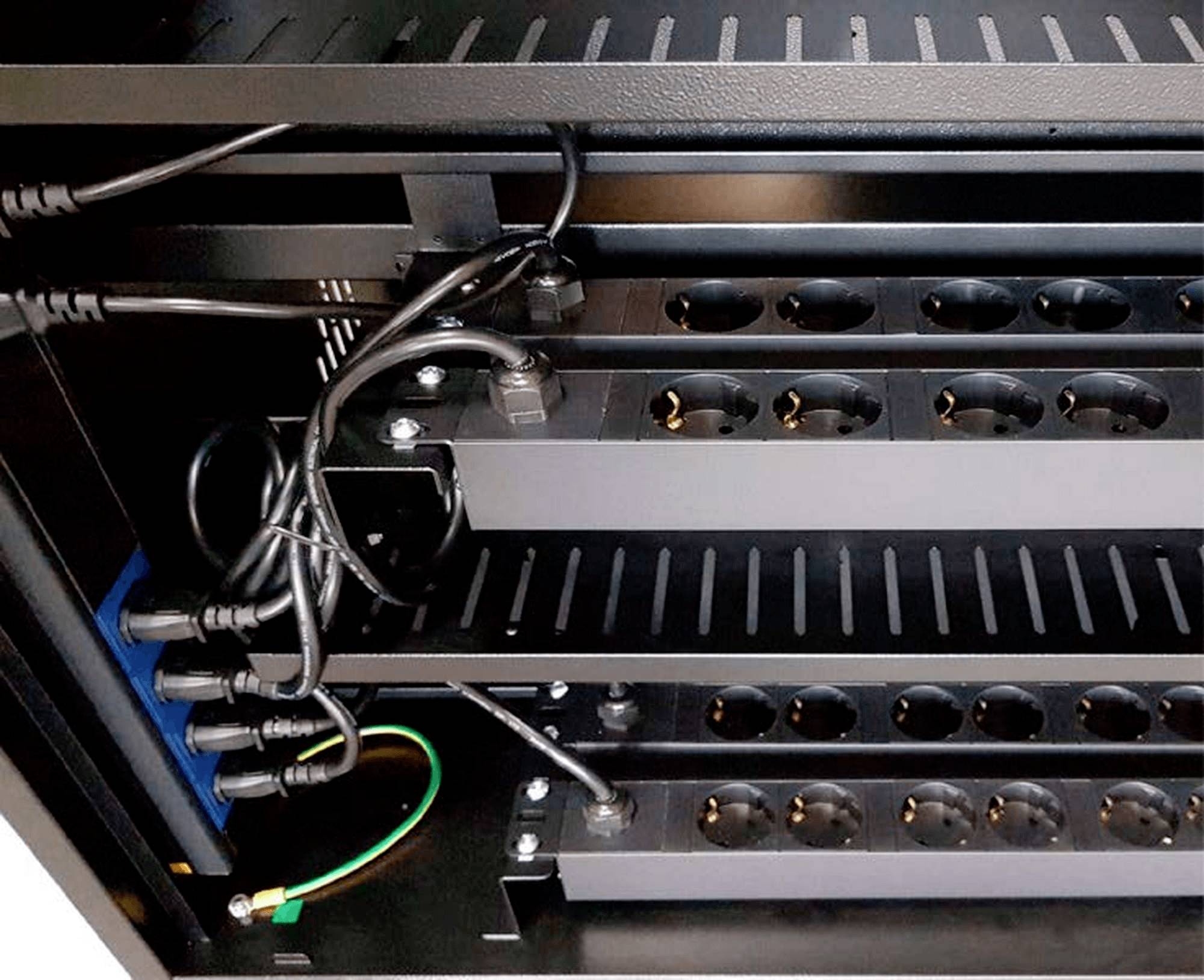 Verschillende zwarte stekkerdozen zijn gemonteerd in een open technische kast, met zichtbaar aangesloten kabels.