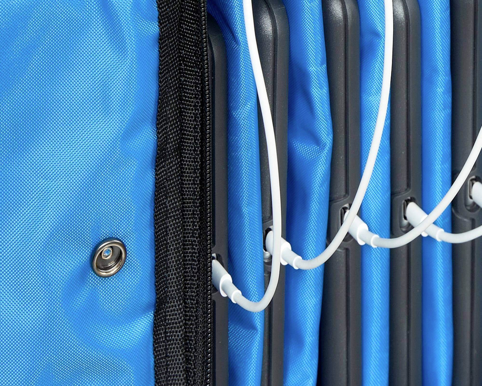 Meerdere tablets liggen naast elkaar in blauwe beschermhoezen met witte oplaadkabels verbonden.