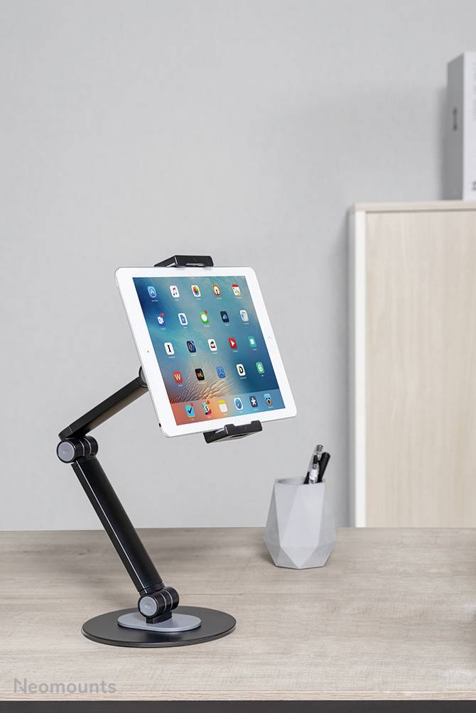 Tablet op een flexibele tafelpoot in een kantoor, naast een pennenhouder.