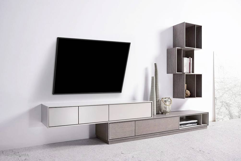 Woonkamer met modern, minimalistisch design: flatscreen-tv aan de muur, hangende en staande planken in houtlook.