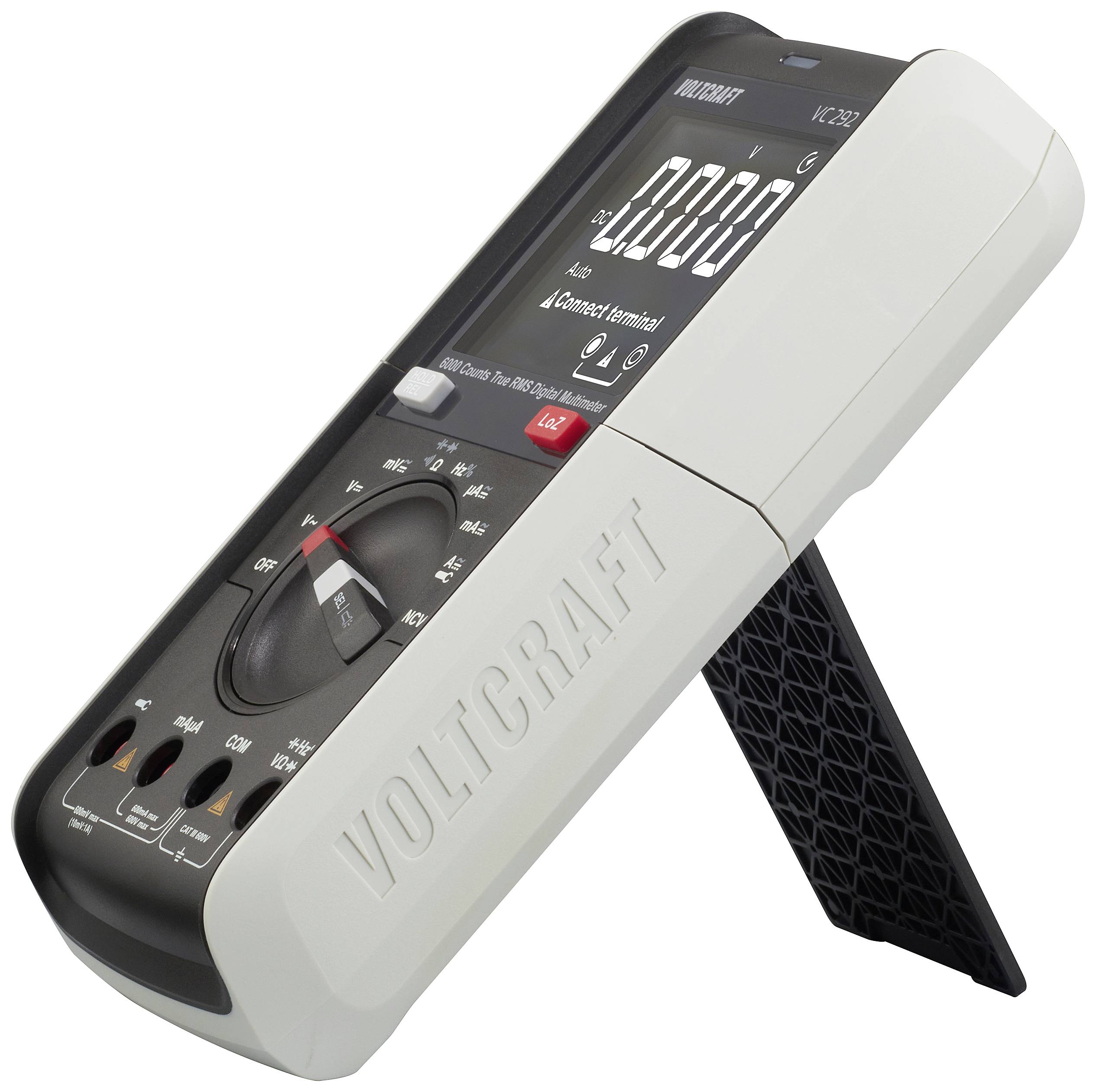 Een digitale multimeter met standaard, toont een nulweergave. Merknaam 'Voltcraft' zichtbaar op de behuizing.