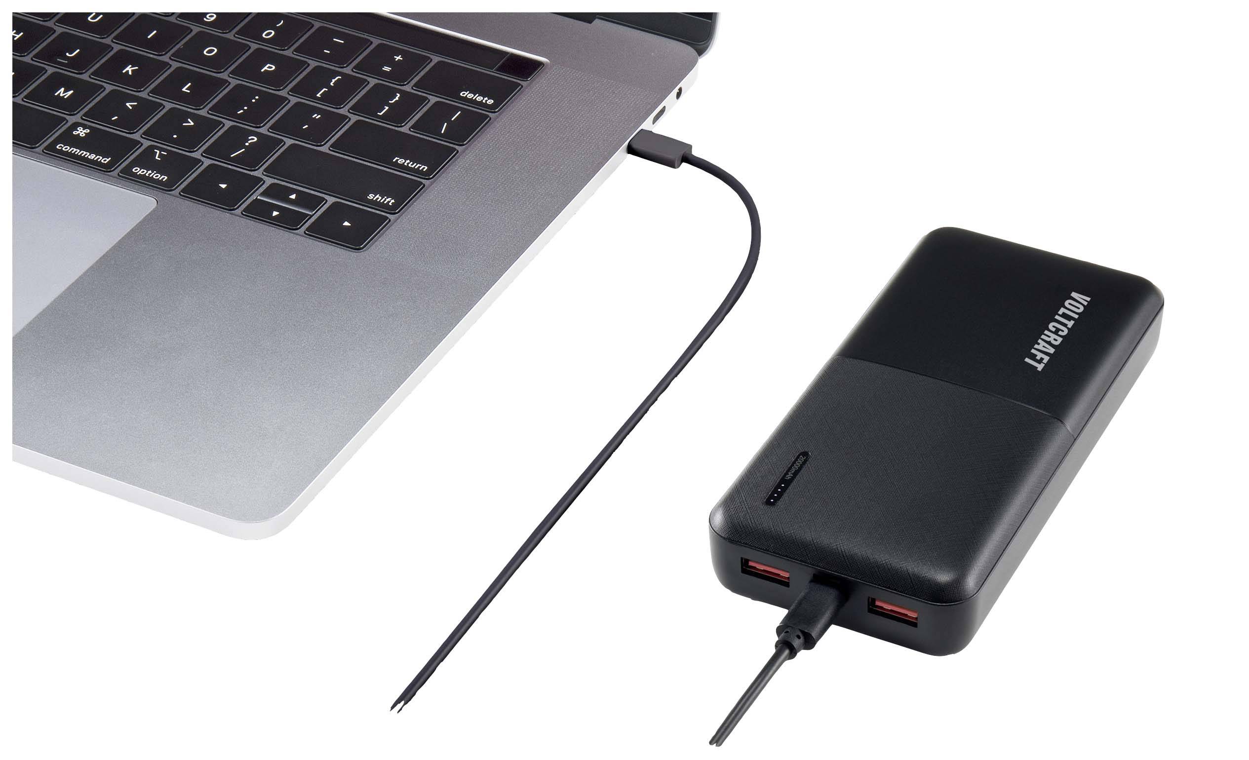 Een laptop is via een USB-kabel verbonden met een powerbank.