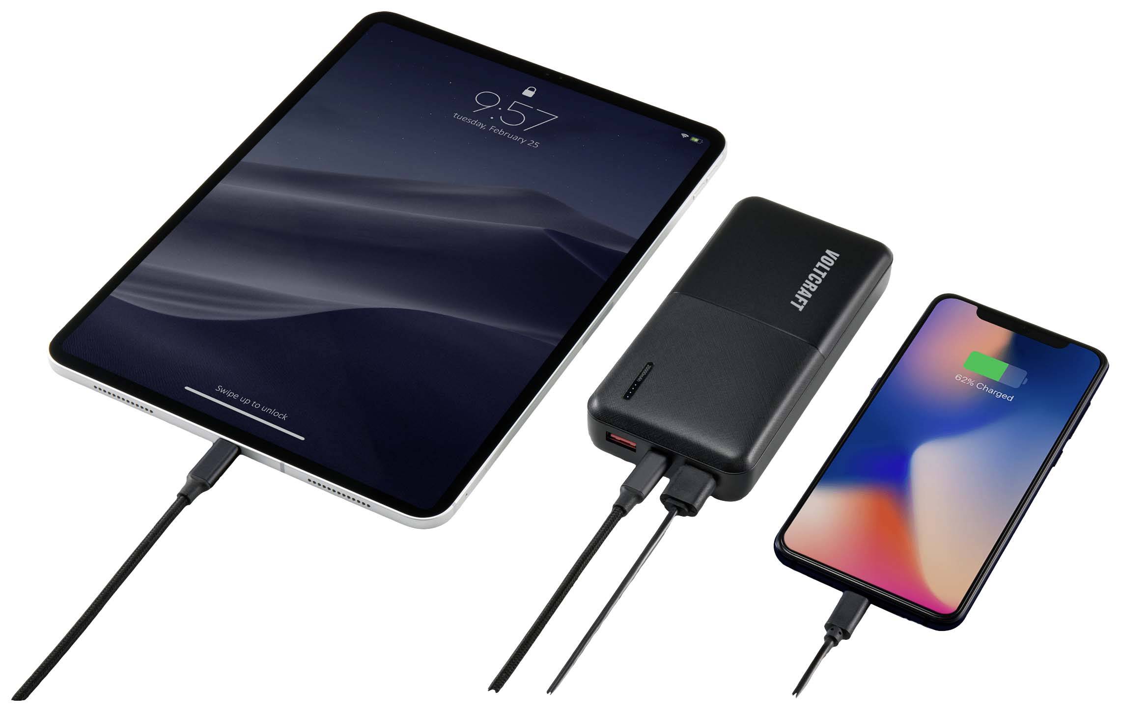 Een tablet, een powerbank en een smartphone zijn via kabels met elkaar verbonden. De smartphone geeft aan dat hij wordt opgeladen.