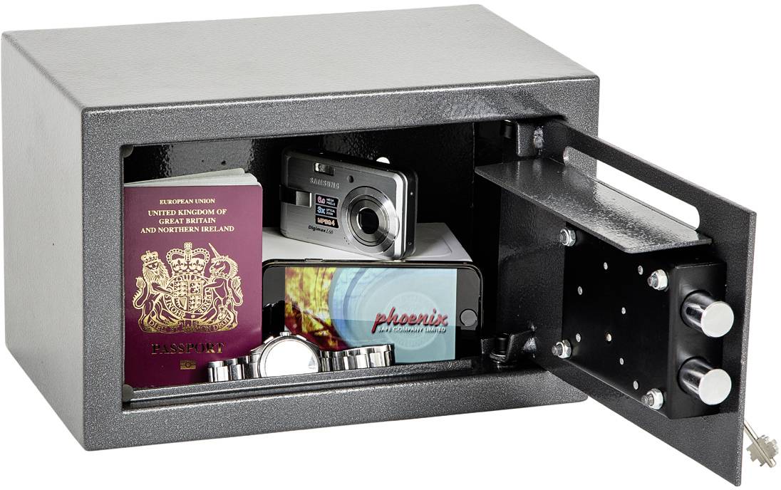 Een open kluis toont een Brits paspoort, een camera, een smartphone en een horloge aan de binnenkant. Sleutels hangen aan de buitenkant.
