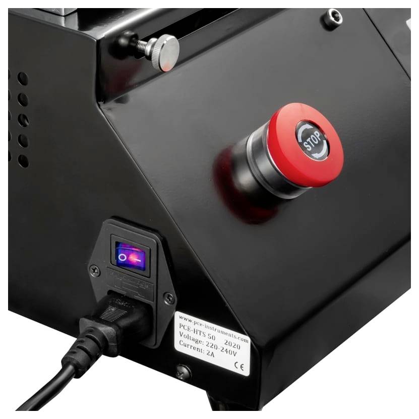Close-up van een zwart machinepaneel met een rode 'STOP' noodstopknop, verlichte stroomschakelaar en aangesloten stromsnoer.