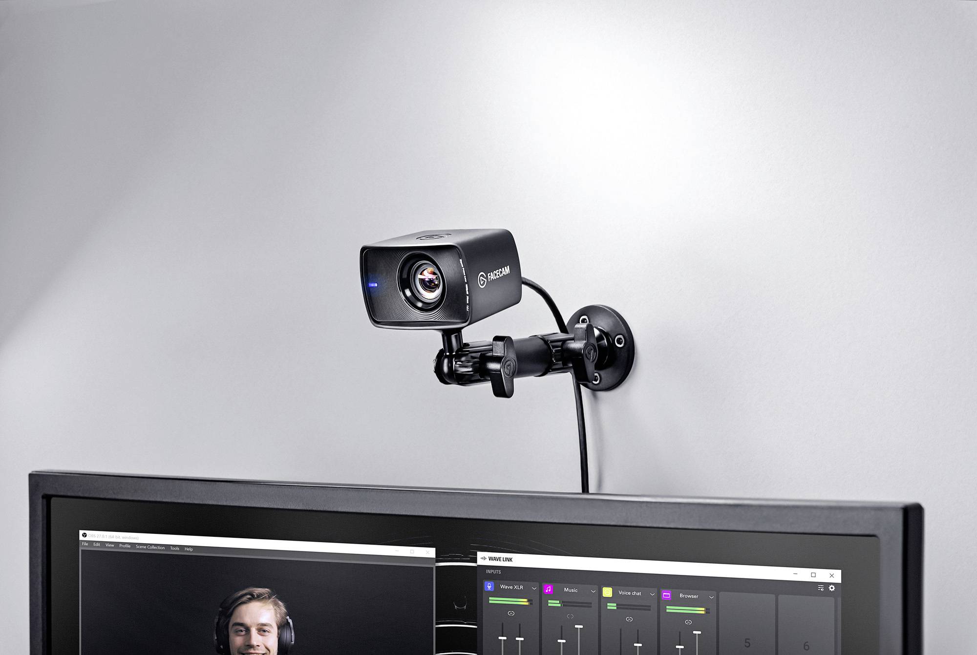Een webcam is op een monitor bevestigd. Op de voorgrond zijn details van de webcam zichtbaar, terwijl op de monitor een videogesprek wordt gevoerd.