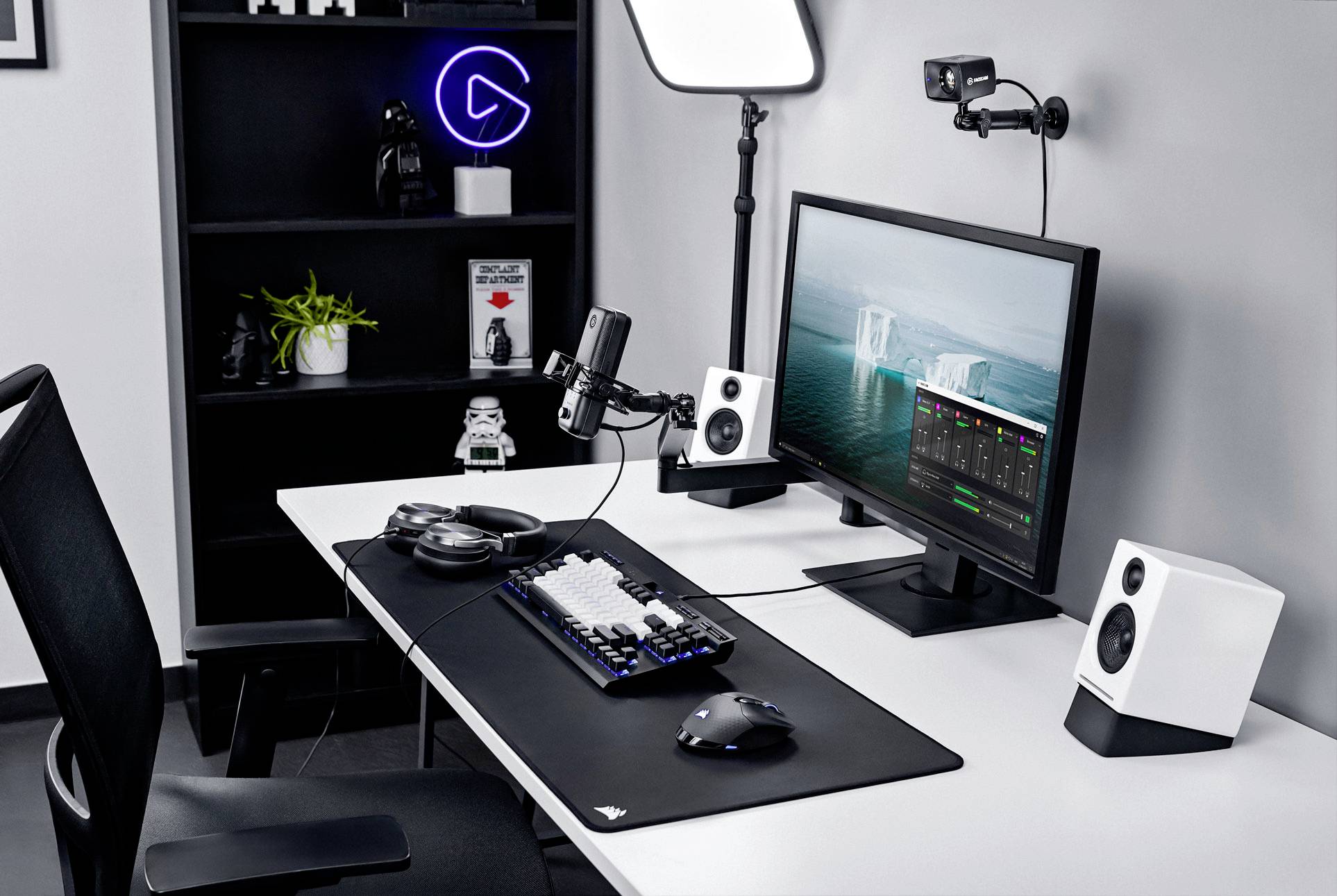 Modern streaming-setup met computer, microfoon, koptelefoon, camera en verlichting; klaar voor podcast of video-opname.