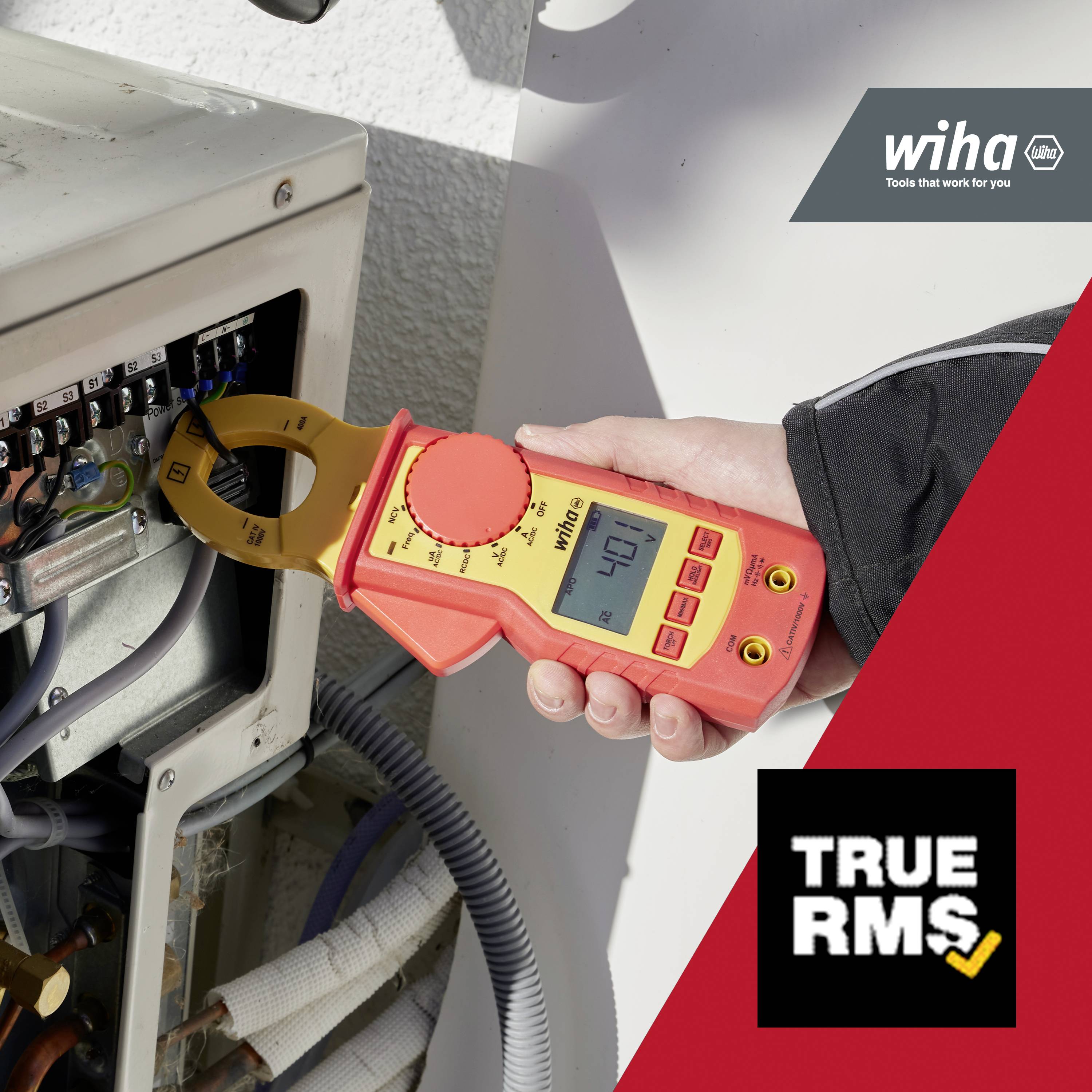 Een persoon meet met een rode en gele meetklem de stroom in een elektrische schakelkast. Op de achtergrond het logo 'Wiha'.