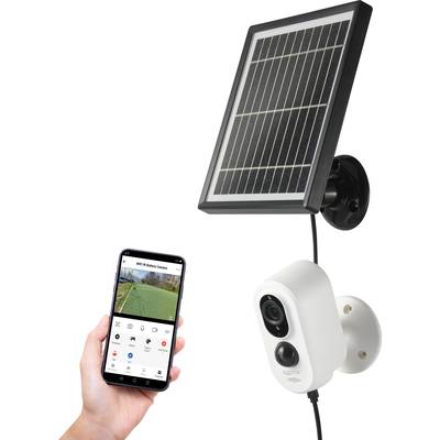Zonnepaneel-beveiligingscamera gemonteerd aan de muur. Een hand vastgehouden smartphone met bewakings-app.