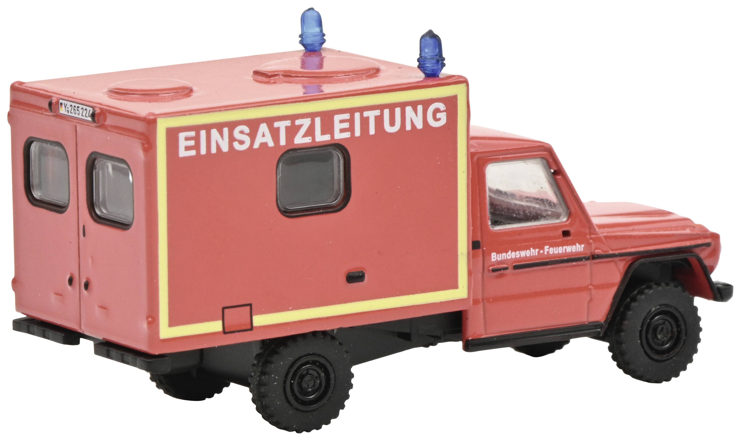 Rode hulpverleningsvoertuig met de tekst 'Operationele leiding' aan de zijkant. Brandweerwagen met zwaailicht op het dak.