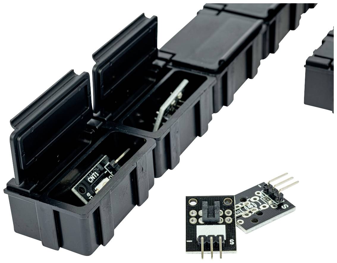 'Zwarte kunststof behuizingen met scharnierende klep, die elektronische componenten beschermen. In één behuizing is een module zichtbaar.'