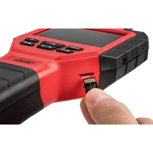 Een rood elektronisch apparaat met toetsen en display wordt getoond. Een hand steekt een microSD-kaart in de zijdelingse kaartsleuf.
