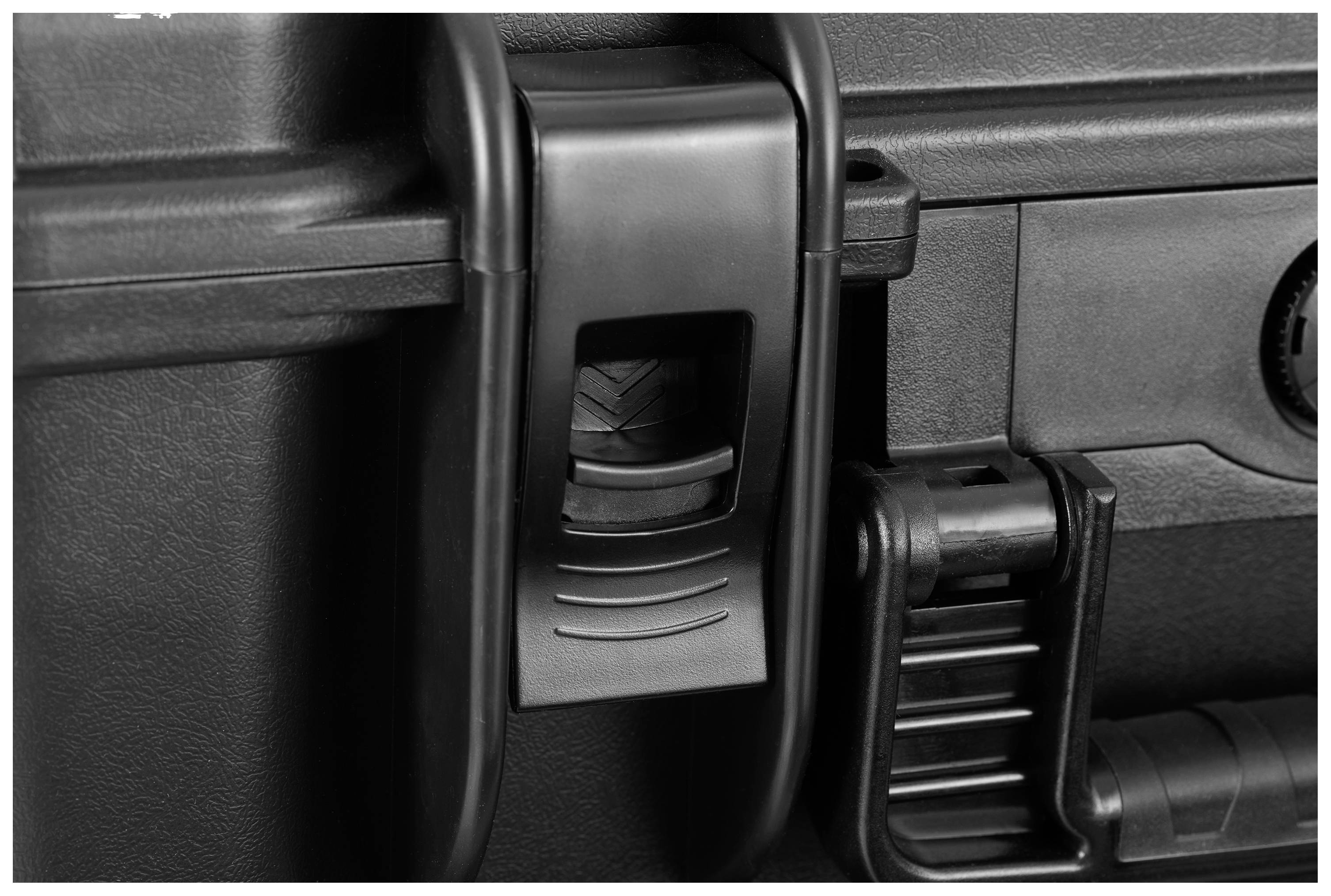 Slot van een zwarte hardshell koffer, waarbij de mechanische sluitingsmechanisme gedetailleerd zichtbaar is.