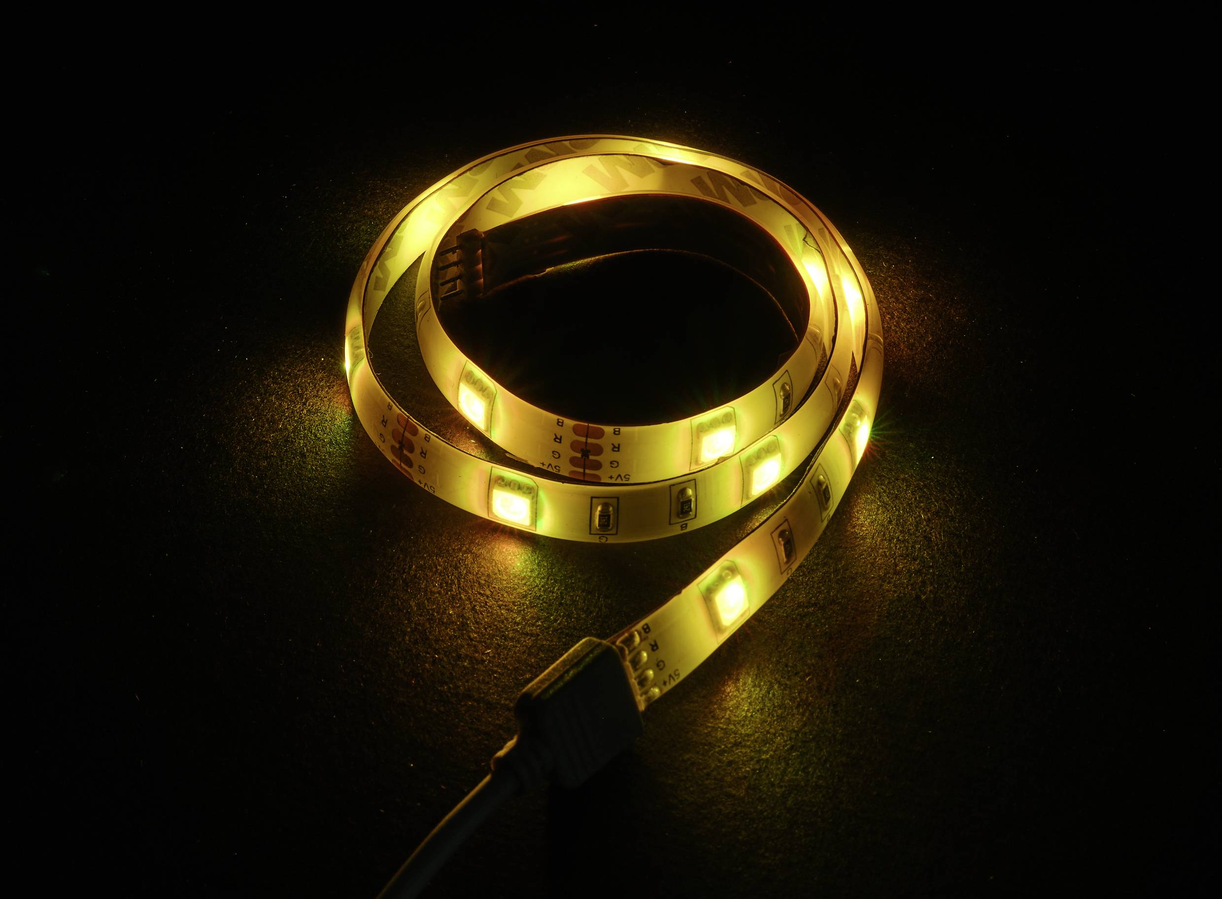 Een fel geel LED-lichtstrip op een donkere achtergrond, toont flexibele verlichtingsoplossingen.