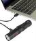 Een zwarte zaklamp is via een USB-kabel verbonden met een laptop. De zaklamp brandt niet.