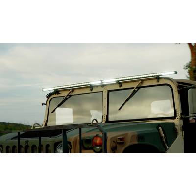 Een militair voertuig buiten, verlicht door LED-lampen op het dak, tegen een bewolkte hemel.