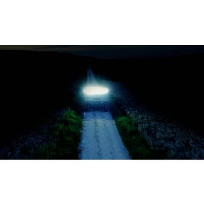 Een voertuig met fel koplamplicht rijdt 's nachts op een verlaten weg. De omgeving is donker en onverlicht.
