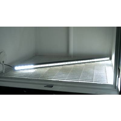 Een lange, lichtgevende LED-lamp ligt diagonaal op een rooster in een lege, verlichte ruimte.