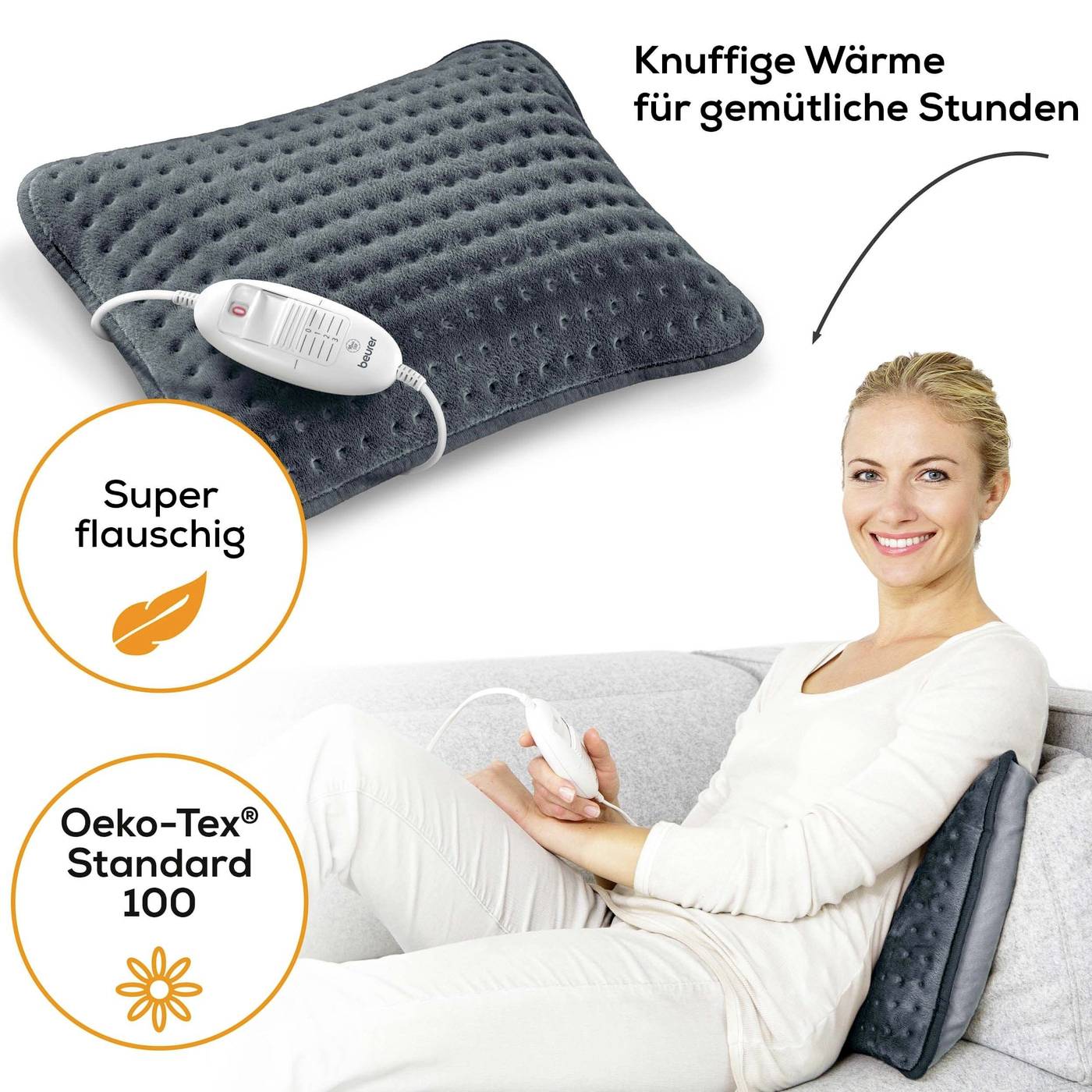 Een vrouw zit op de bank met een donker warmtekussen. Tekst: 'Knuffige warmte voor gezellige uurtjes', 'Super zacht'. Oeko-Tex® Standard 100.