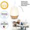 Een aroma-diffuser met houtdesign die geuren verspreidt met behulp van ultrasone technologie. Een stel ontspant ernaast op de bank.