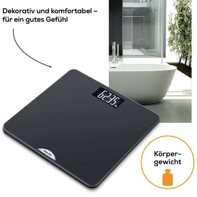 Een zwarte personenweegschaal met digitale weergave die 62,3 kg aangeeft. Naast de weegschaal is een stijlvolle badkamer te zien.