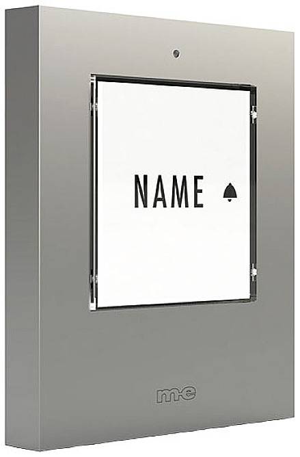 Een deurintercom met een kleine naamplaathouder, daaronder het woord 'NAAM' en een belsymbool, aan een muur bevestigd.