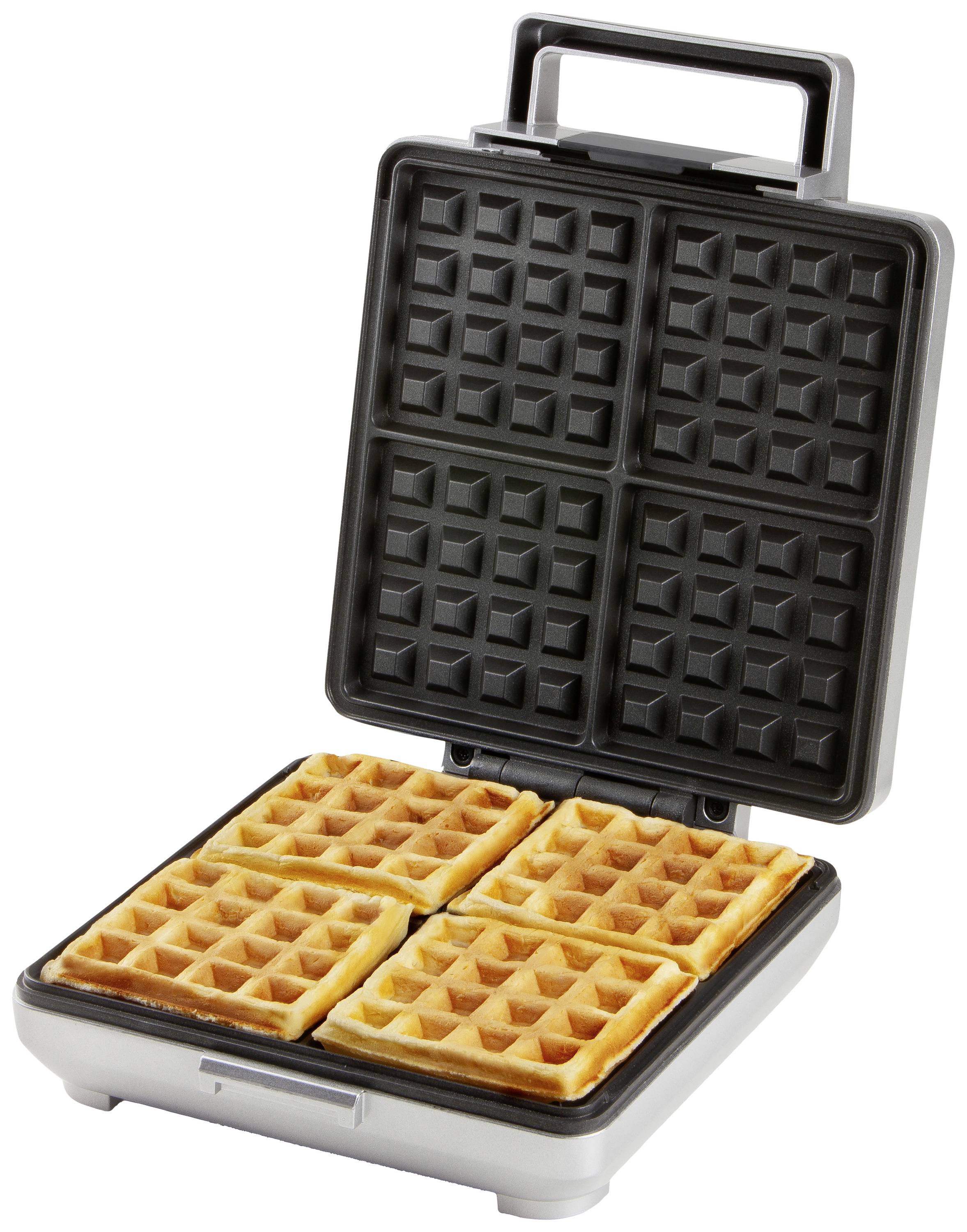 Een wafelijzer met opengeklapte deksel toont vier goudbruine wafels in vierkante vorm.