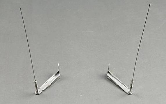 Twee metalen antennes rechtop op een grijze oppervlakte. Ze zijn bevestigd aan kleine houders.