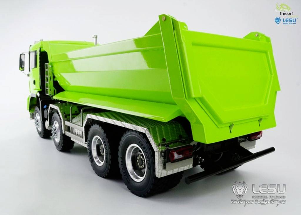 Groene vrachtwagen met zes wielen, zijaanzicht en achteraanzicht, op een lichte achtergrond. De merklogo's zijn zichtbaar op de laadvloer.