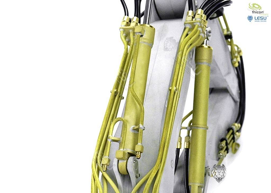 Close-up van gele hydraulische slangen en kleppen op een metalen voertuigonderdeel. Logo in de hoek.