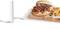 Een burger met tomaten, uien en sla geserveerd op een houten plank, naast frietjes en een glas melk.