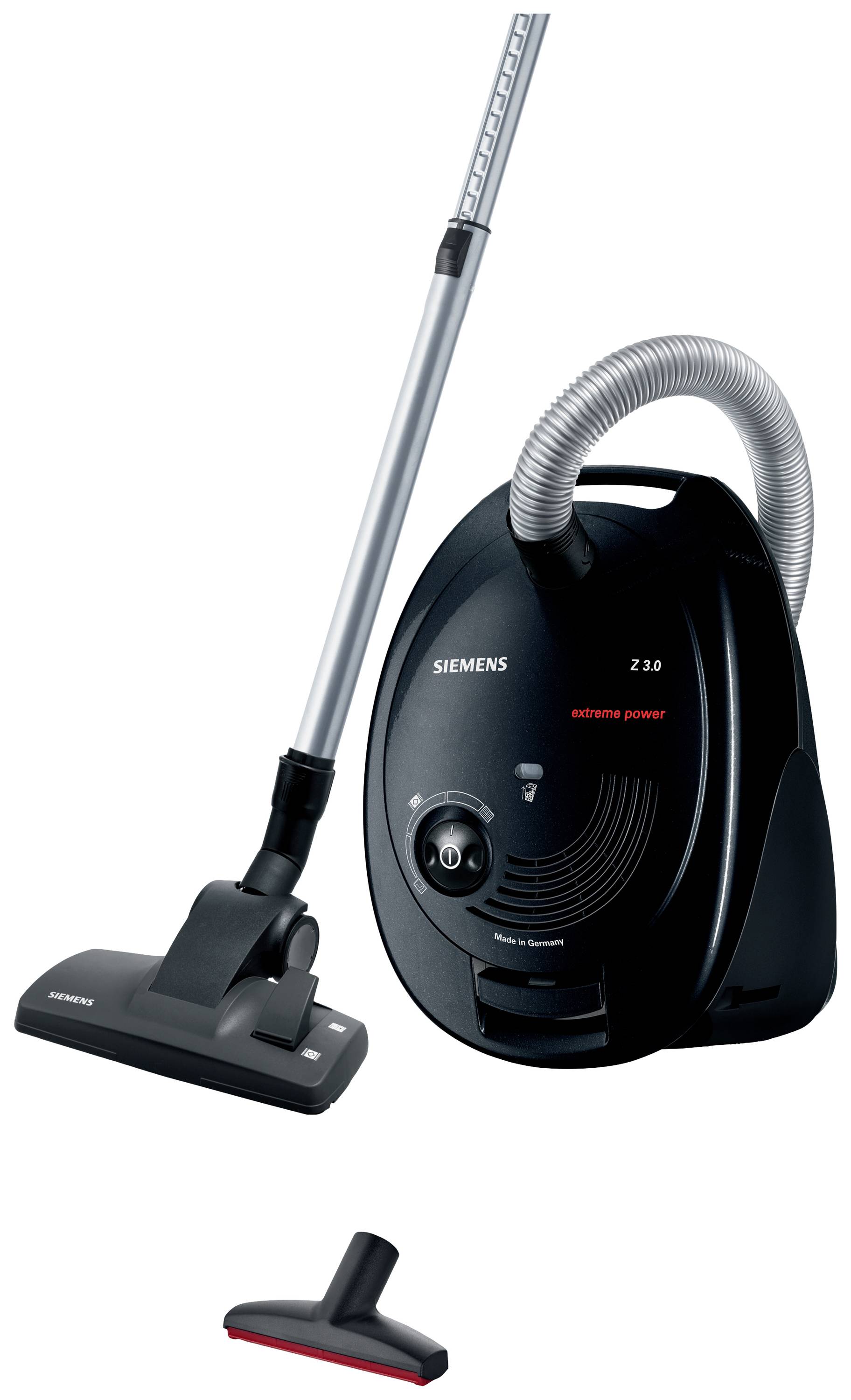 Een zwarte stofzuiger van het merk Siemens met slang en vloerzuigmond, ernaast een extra mondstuk.