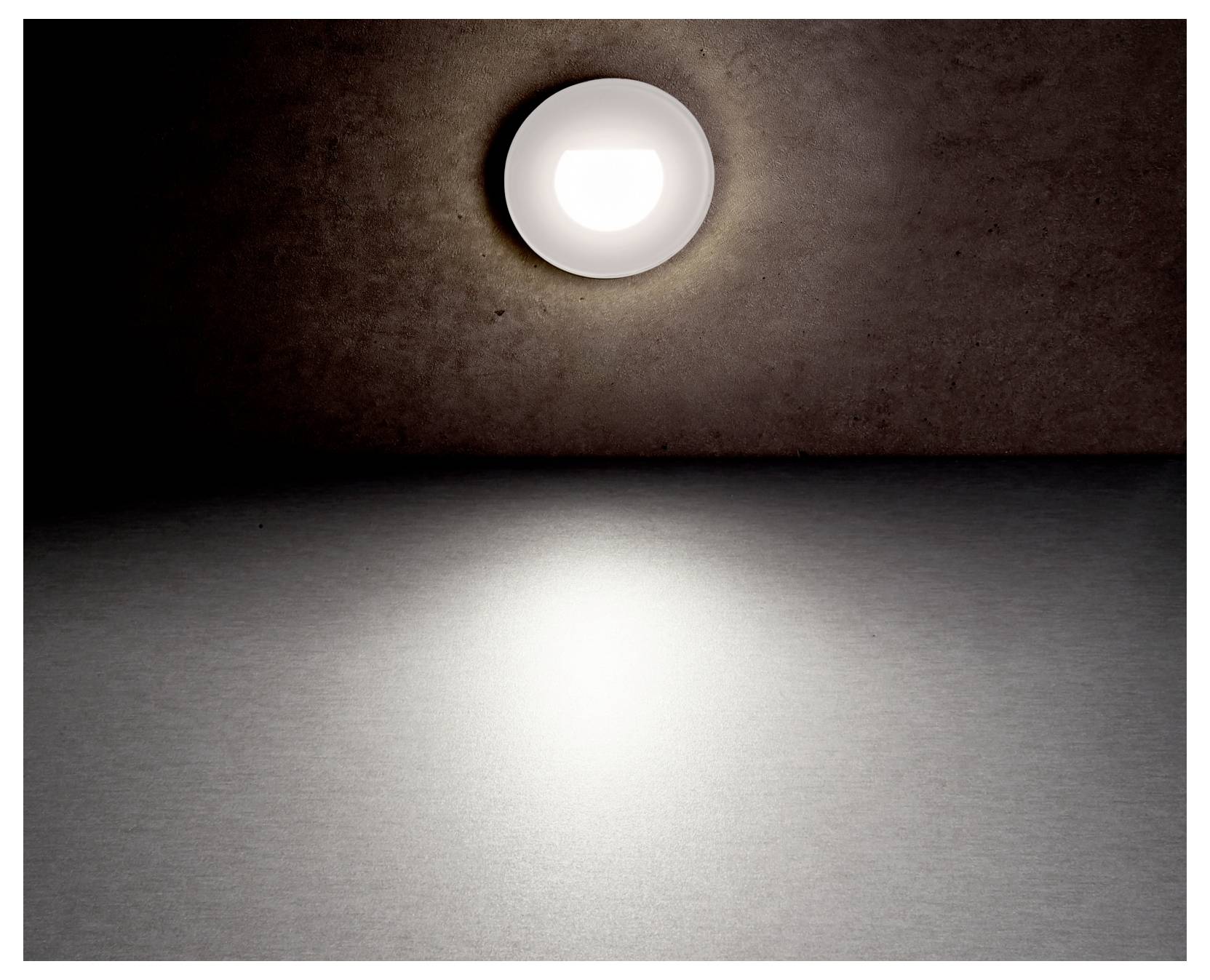 Een enkele ronde wandlamp gloeit tegen een donkere muur en werpt een helder lichtvlek op de verder lege vloer van de kamer.