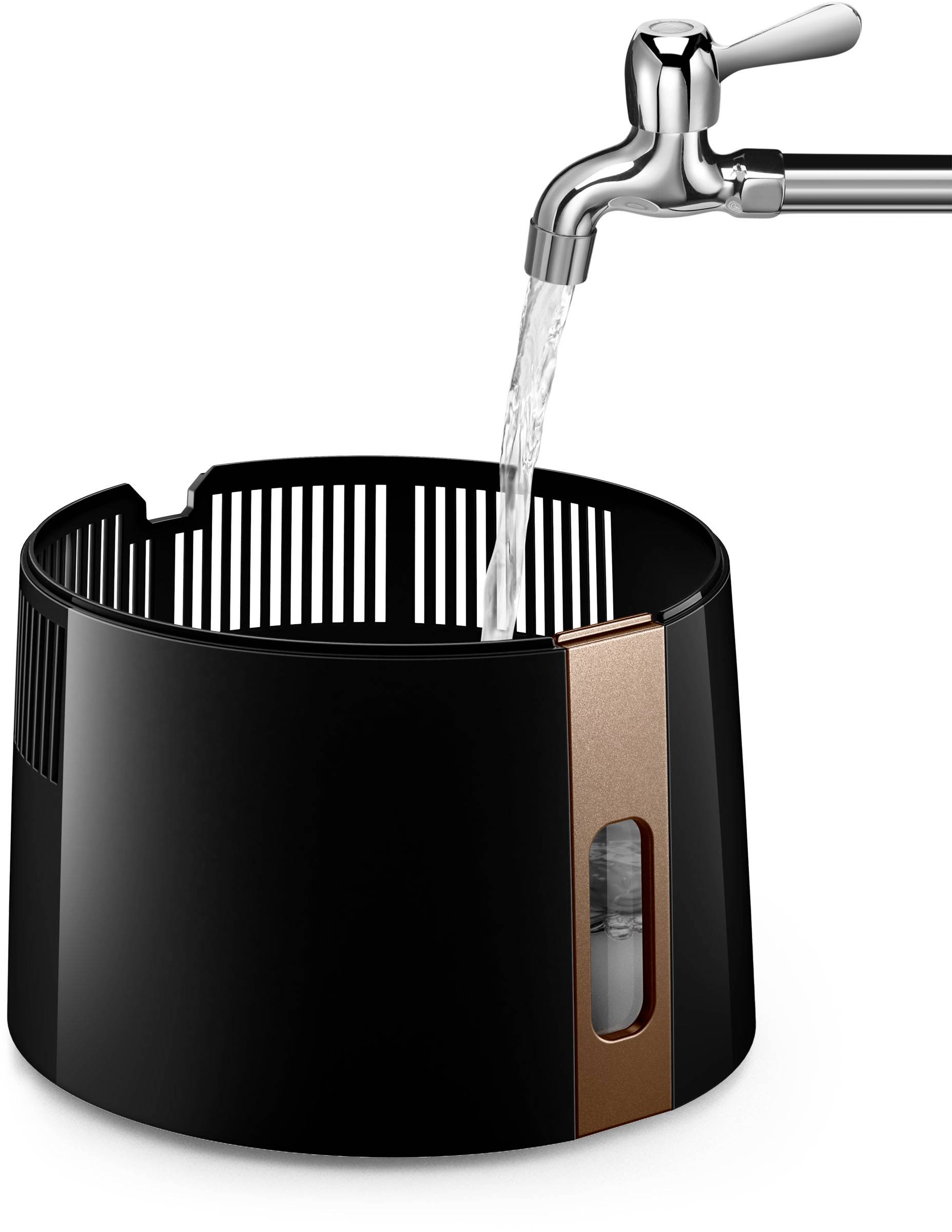 Een zwarte watercontainer met een koperkleurige streep en maatschaal wordt gevuld onder een kraan met stromend water.