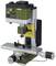 Een groene tafelfreesmachine met besturingseenheid en ingebouwde boor. Op een beweegbare tafel zijn klemmen gemonteerd.