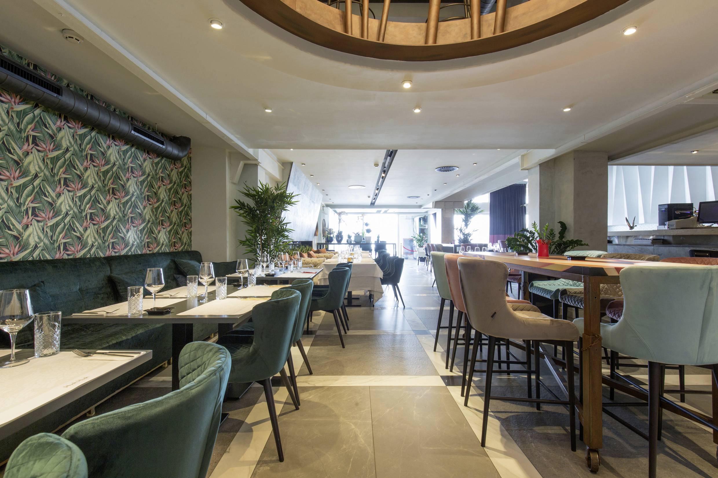 Interieur van een modern restaurant met elegante inrichting. De tafels zijn gedekt en de sfeer is uitnodigend en stijlvol.