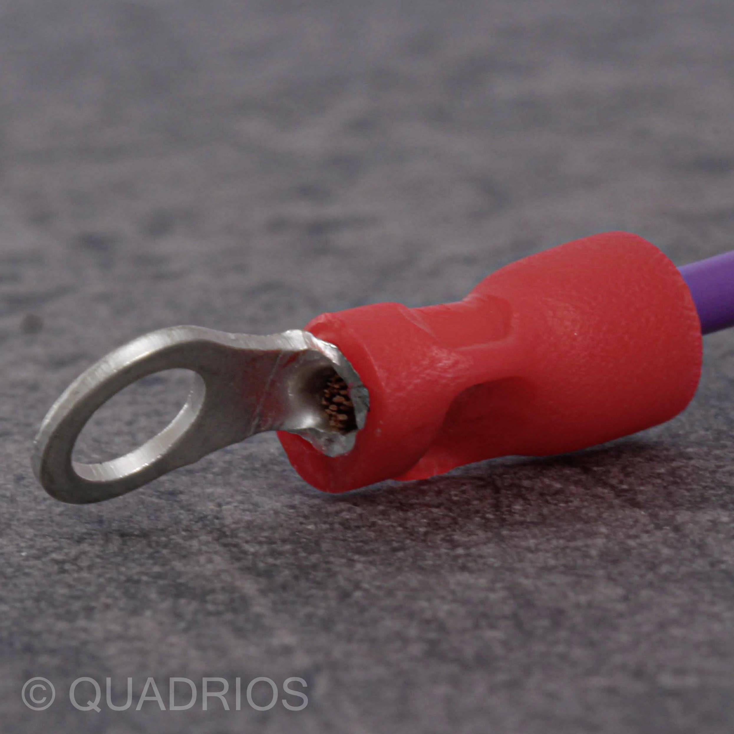Rode geïsoleerde kabelschoen op grijze achtergrond, toont metalen oog en verbindingsdeel. Gemarkeerd met 'Quadrios'.