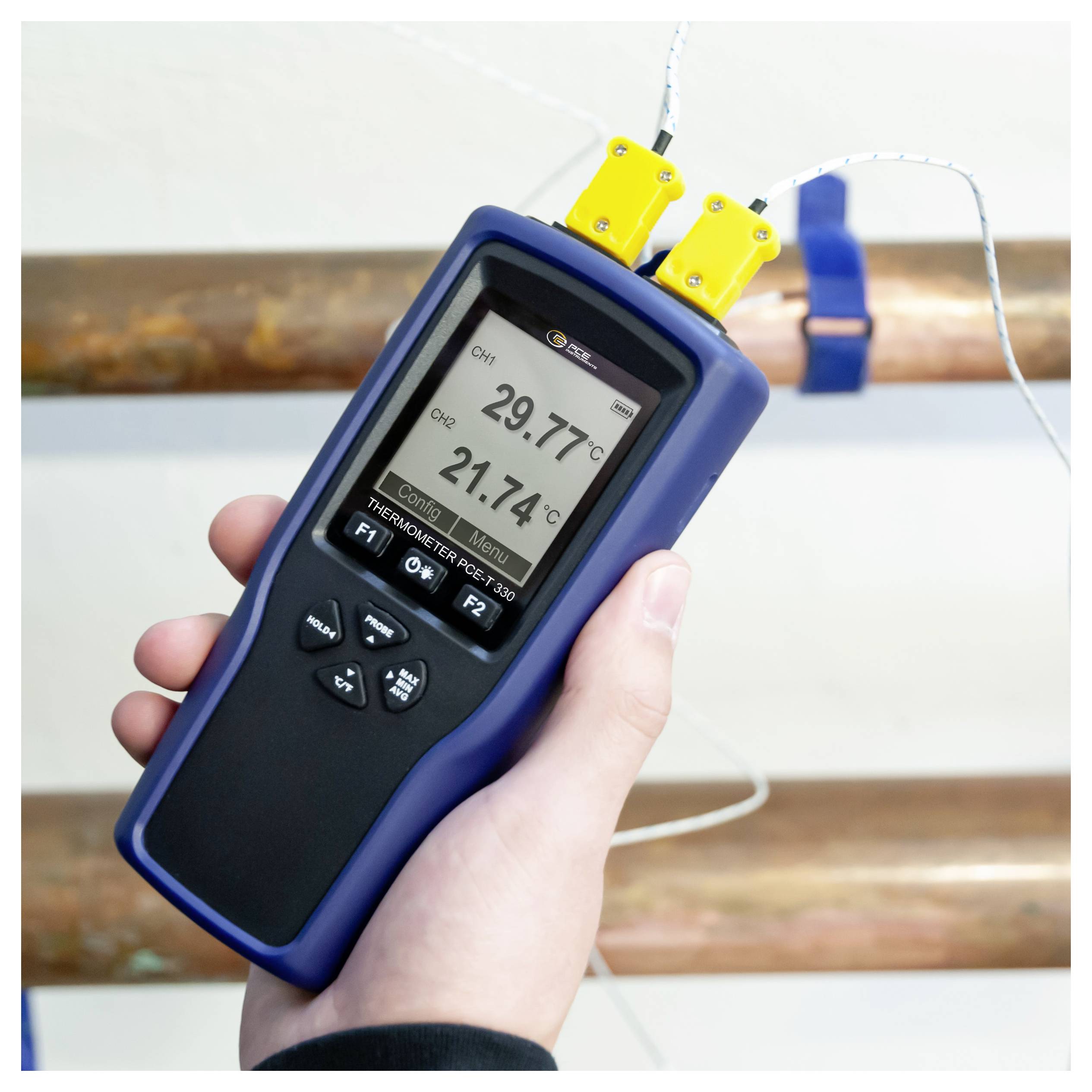 Handheld thermometer meet twee pijptemperaturen, met 29,77°C en 21,74°C op het display.