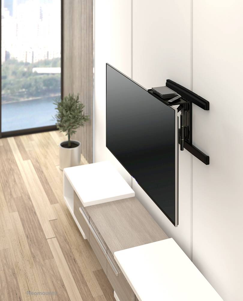 Een flatscreen-tv is bevestigd aan een kantelbare wandsteun, in een modern woonkamer met houten vloer en panoramisch raam.